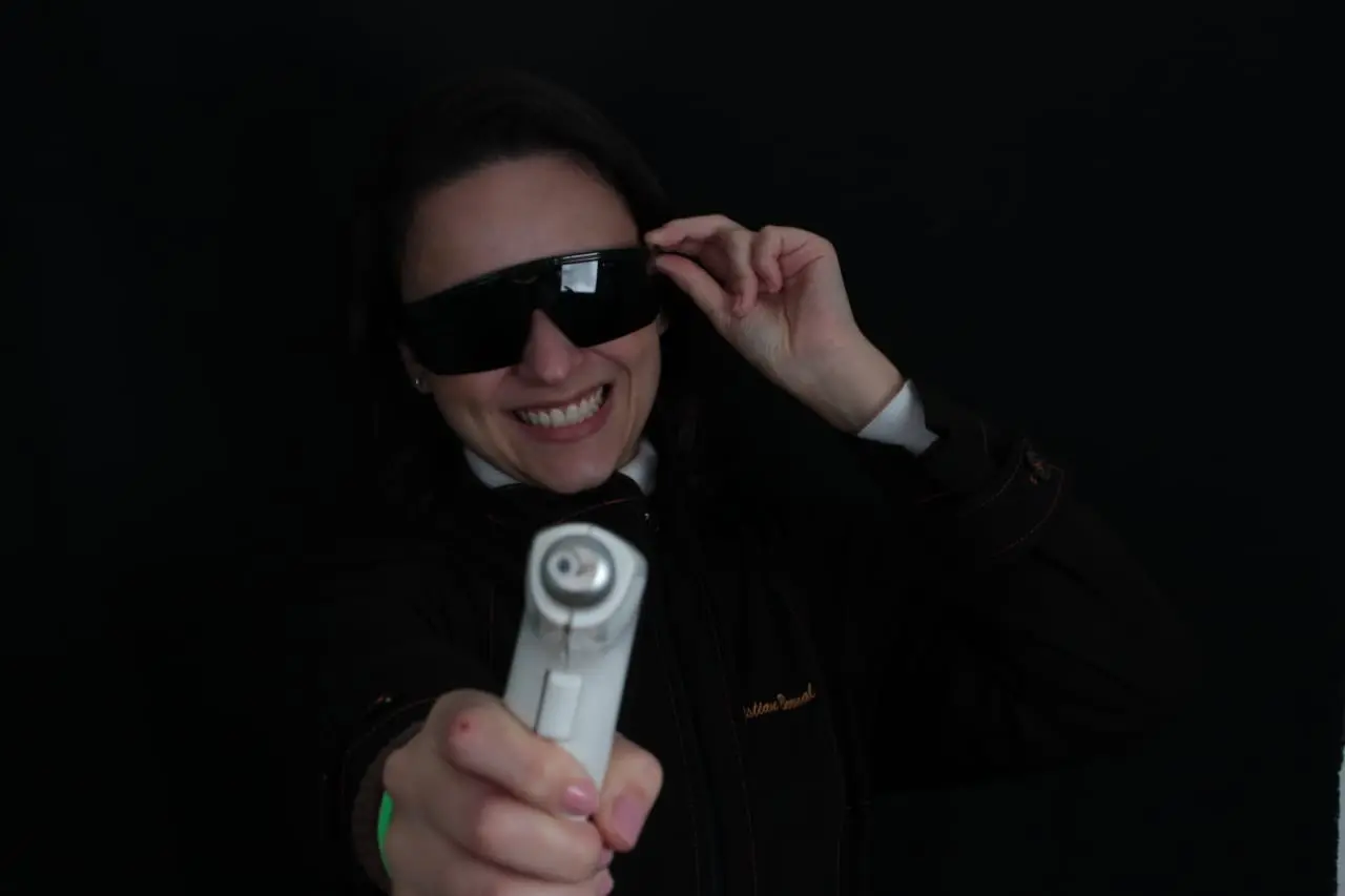 Dra. Maria Cecília segurando equipamento de laser odontológico na Studio Orale