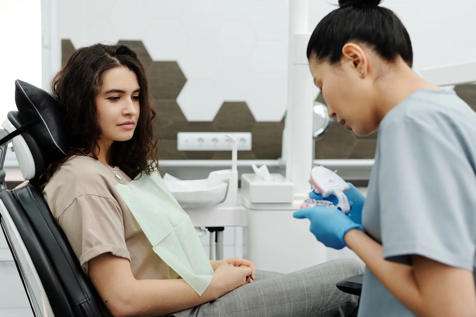 Dentista explicando um modelo odontológico durante uma consulta